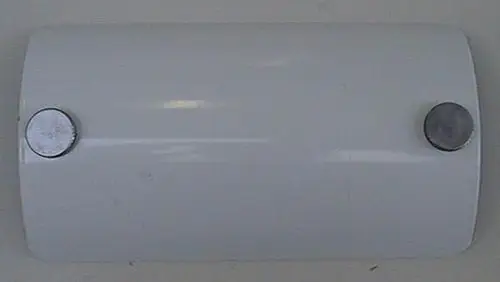 Weißer runder Deckel mit zwei Metallknöpfen, möglicherweise für eine Revisionsöffnung, Hersteller Brötje. Auf glatter Oberfläche, schlichtes Design.
