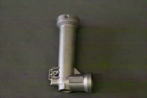 Brötje Produkt, metallisches Bauteil mit einem Rohr und einer seitlichen Anschlussmöglichkeit, auf grauem Hintergrund.