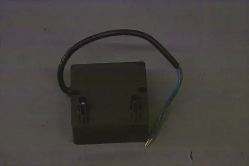 Brötje Zündtrafo mit zwei Anschlüssen und einem Kabel, auf grauem Untergrund. Das Produkt hat eine kompakte, rechteckige Form.