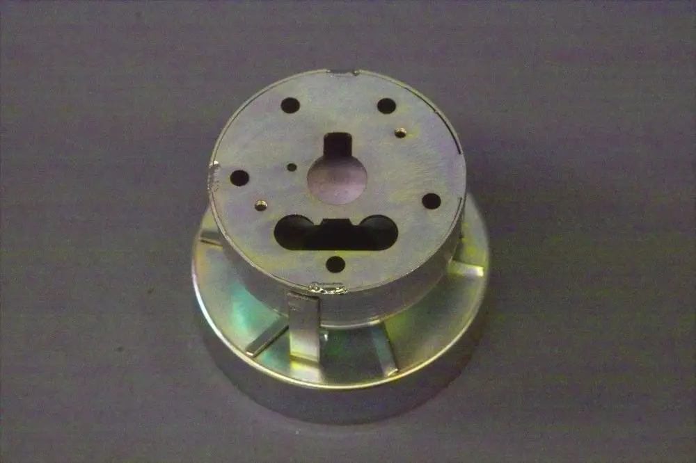 Metallische Stauscheibe von Brötje mit mehreren Bohrungen und Ausschnitten. Die Oberfläche zeigt eine glänzende, reflektierende Beschichtung.
