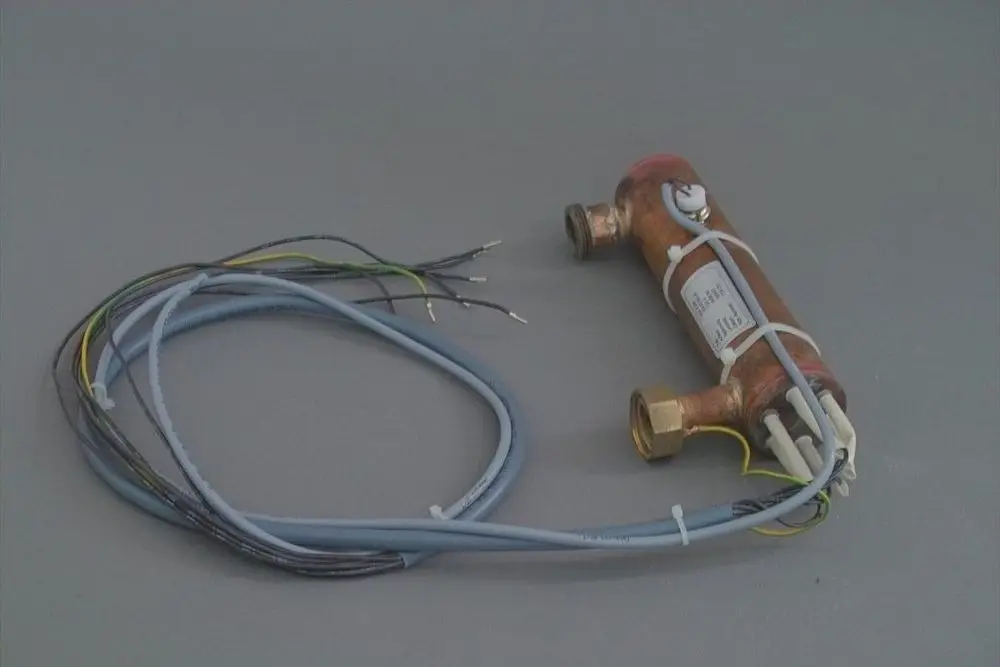 Brötje Durchlauferhitzer mit mehreren Kabeln und Anschlüssen, montiert in einem kompakten, zylindrischen Gehäuse. Gezeigt werden die elektrischen Verbindungen.