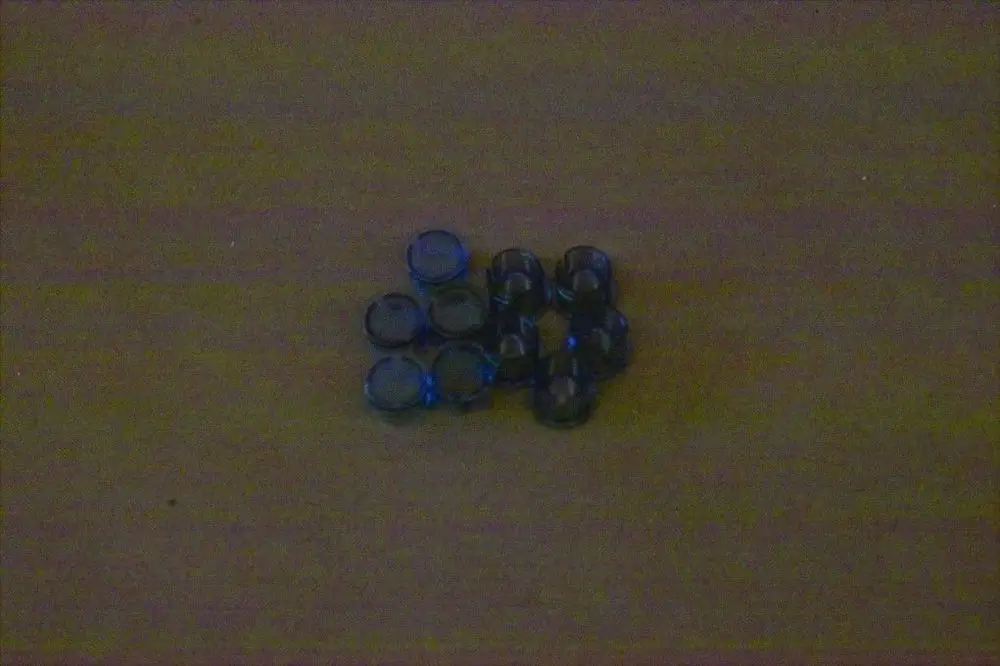 Mehrere schwarze Stopfen mit blauen Rändern in zwei verschiedenen Größen liegen auf einem hellen Untergrund. Es handelt sich um Produkte der Marke Brötje.