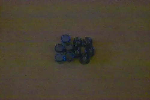 Mehrere schwarze Stopfen mit blauen Rändern in zwei verschiedenen Größen liegen auf einem hellen Untergrund. Es handelt sich um Produkte der Marke Brötje.