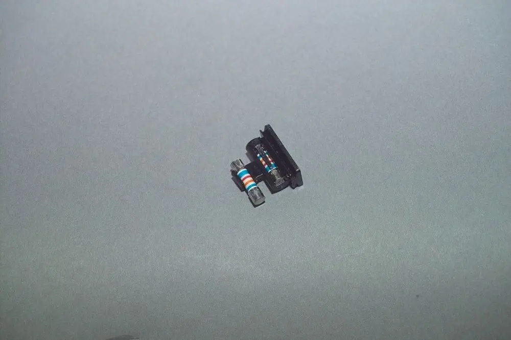 Brötje Sicherungshalter, der eine Glas- und eine elektrische Sicherung in einer Halterung kombiniert. Auf grauem Hintergrund abgebildet.
