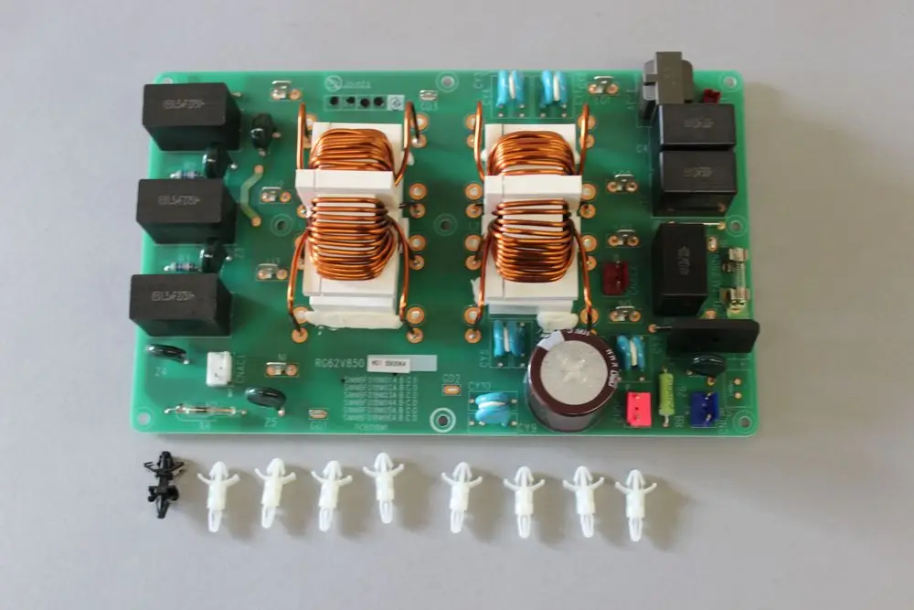 Brötje Elektronikfilterplatine mit mehreren Relais, Transformatoren und Bauteilen auf grüner Leiterplatte. Mehrere Kabelbinder und kleine Bauteile im Vordergrund.
