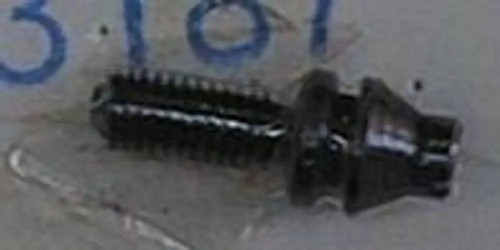 Schwarze Druckregulierschraube von Brötje mit einem gewellten Schaft, stehend auf einer flachen Oberfläche.