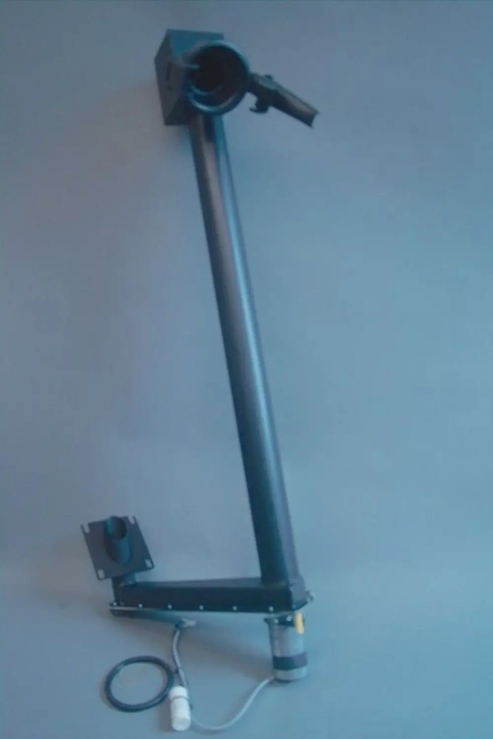 Schwarze Pelletzuführung mit einem langen, geraden Rohr und einem Motor mit Kabel, designed für den Betrieb mit Brötje-Heizsystemen.