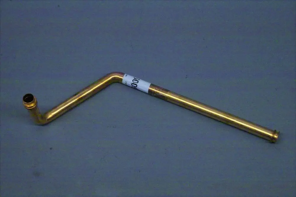 Brötje Rücklaufrohr aus Metall mit einer gebogenen Form und einer Anschlussöffnung an einem Ende.