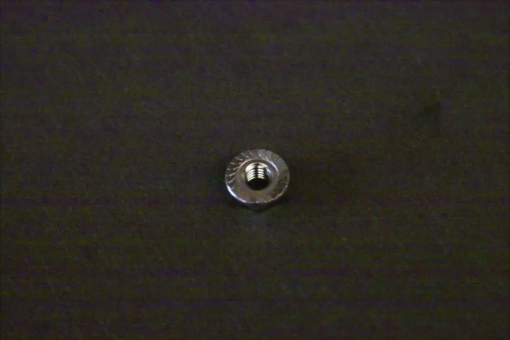 Metallische Fixiermutter von Brötje, rund mit Innengewinde, auf dunklem Hintergrund.