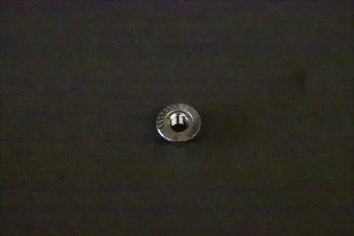 Metallische Fixiermutter von Brötje, rund mit Innengewinde, auf dunklem Hintergrund.