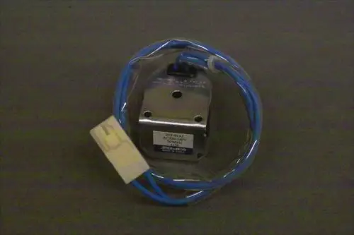 Brötje Magnetventil mit zwei blauen Drähten und einem weißen Stecker. Das Gehäuse ist aus Metall und in einer transparenten Verpackung.