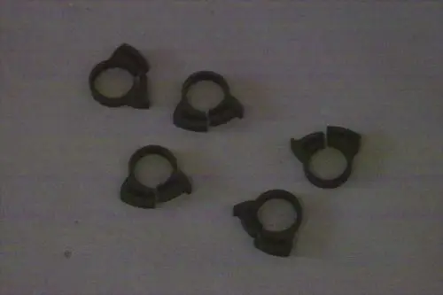 Fünf schwarze Schlauchklemmen von Brötje auf einer hellen Oberfläche. Die Klemmen haben eine charakteristische Form mit einer Öffnung zur Befestigung von Schläuchen.