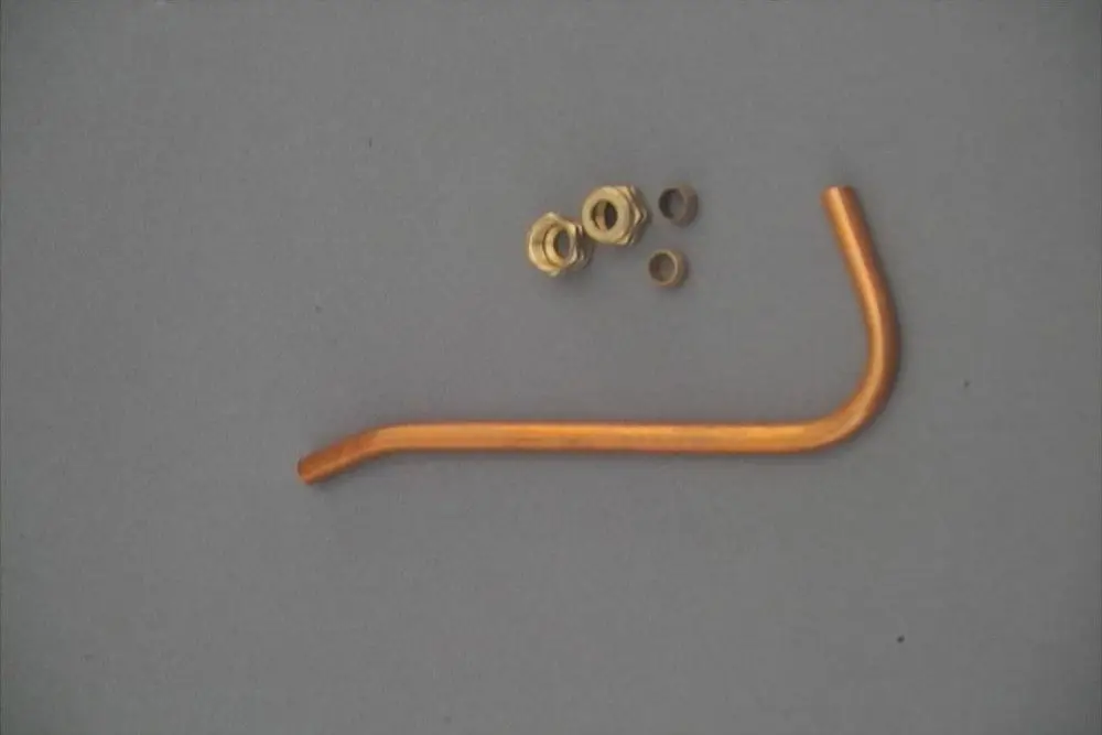 Brötje Lager, bestehend aus einem gebogenen, orangefarbenen Röhrchen und mehreren Metallringen.