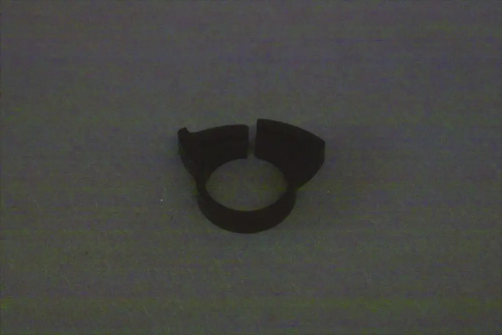 Schwarze Schlauchschelle, die von der Marke Brötje stammt, auf grauem Hintergrund. Sie hat eine offene Form mit einem runden inneren Durchmesser.
