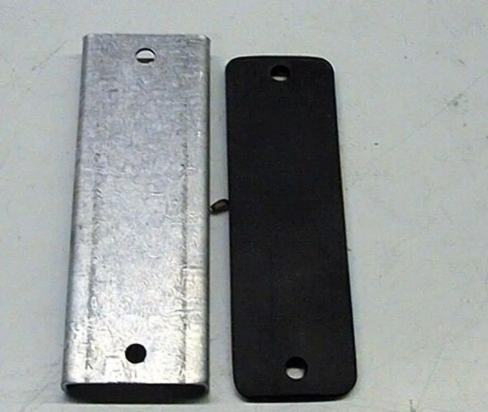 Zwei Verschlussplatten, eine aus Metall und eine aus Kunststoff, nebeneinander liegend. Brötje kann auf der Metallplatte sichtbar sein.