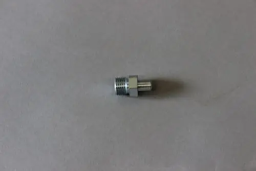Metallisches Verbindungselement von Brötje, mit Innen- und Außengewinde, auf grauem Untergrund liegend.