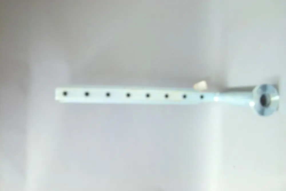 Brötje-Verteiler mit einer langen, leeren Halterung und mehreren Löchern zur Befestigung, aus Metall und in einer hellen Farbe.