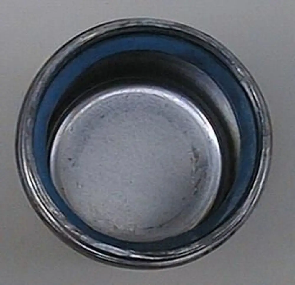 Runder Metalldeckel mit einem inneren blauen Rand, geeignet für den Einsatz bei Brötje-Produkten. Sichtbare Abnutzungserscheinungen im Inneren der Abdeckung.