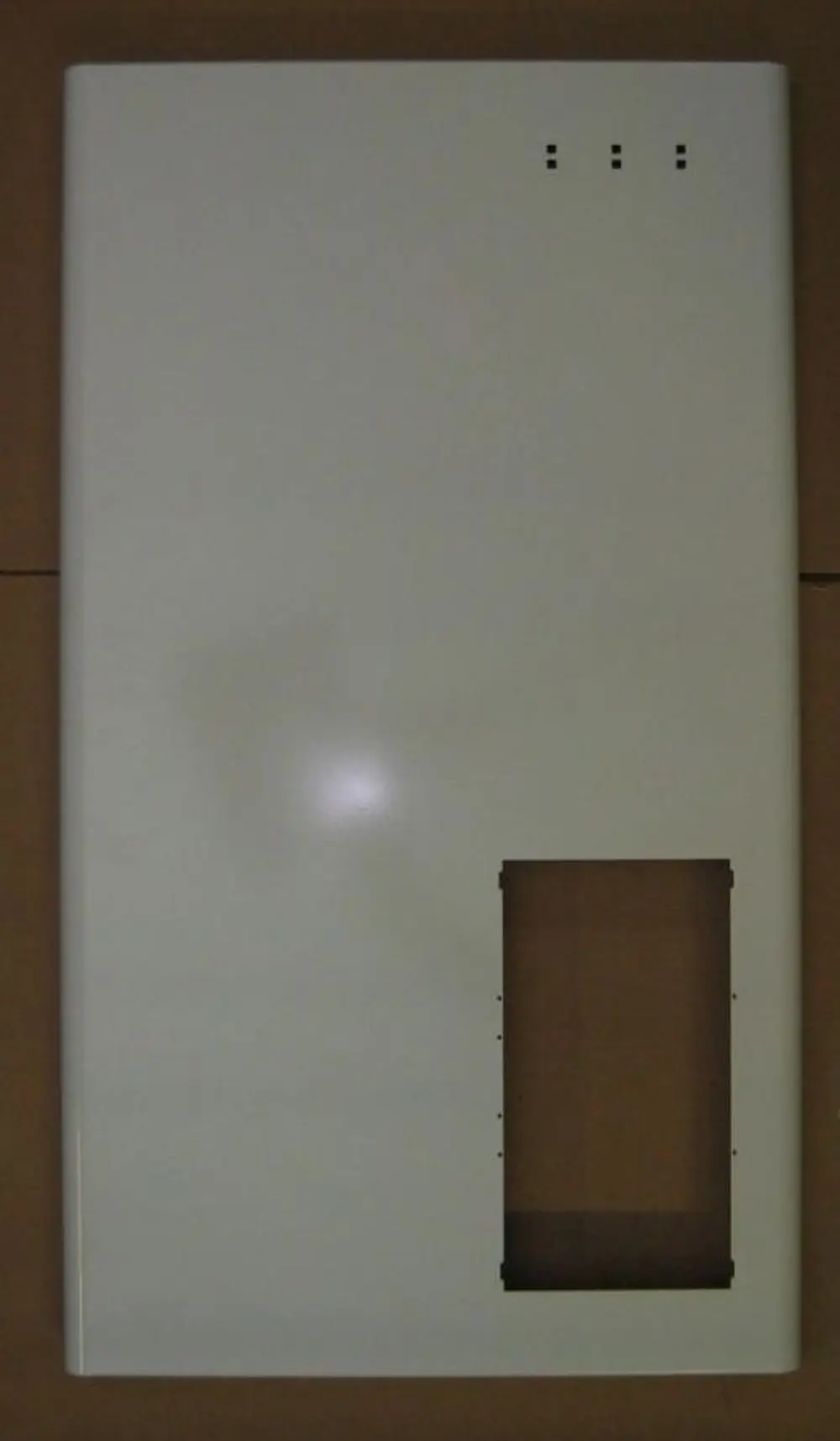 Weiße metallene Vorderwand von Brötje mit rechteckigem Ausschnitt und drei kleinen Bohrungen oben.