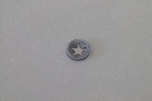 Kleiner, runder Metallring mit sternförmiger Aussparung, möglicherweise ein Klemmring von Brötje für die Befestigung von Metallstiften.