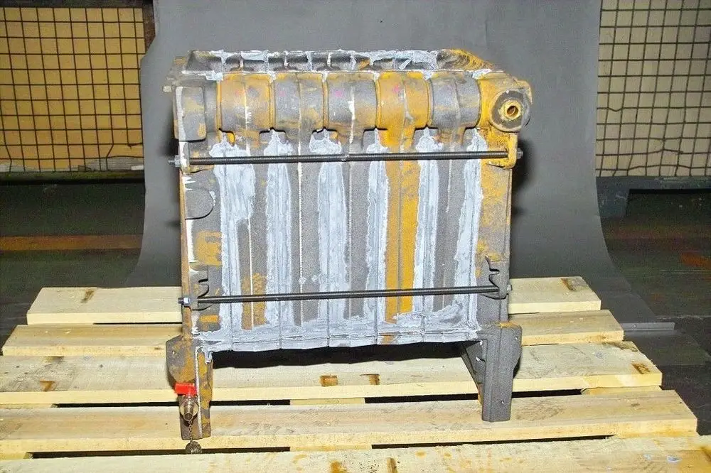 Brötje Kesselblock auf Holzpalette. Manifold und Anschlüsse sichtbar, mit Schweißspuren und gelben Markierungen. Konstruktion mit mehreren Kammern ist erkennbar.
