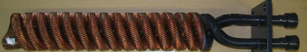 Kupferfarbener Wärmetauscher mit gewelltem Design und zwei Anschlüssen. Produkt von Brötje, verwendet in Heizsystemen zur thermischen Ablaufsicherung.
