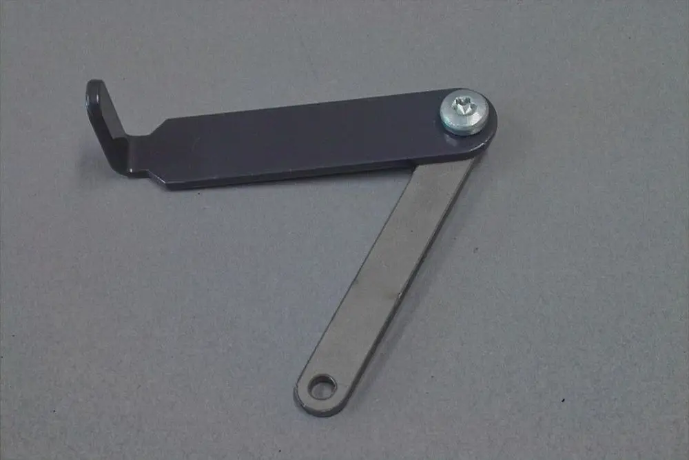 Brötje Luftregulierungselement in Form eines Gelenks mit zwei Metallarmen und einer Verschraubung, geeignet für die Anpassung von Luftstrom in Heizsystemen.