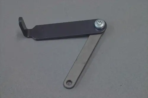 Brötje Luftregulierungselement in Form eines Gelenks mit zwei Metallarmen und einer Verschraubung, geeignet für die Anpassung von Luftstrom in Heizsystemen.