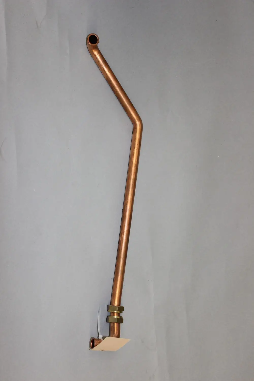 Kupfernes Vorlaufrohr mit einer gebogenen Form und einer Verbindungsmutter, geeignet für Heizsysteme der Marke Brötje.