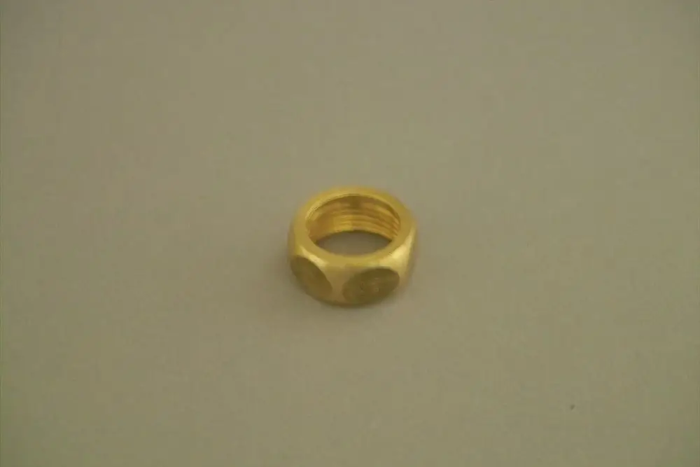 Goldfarbene Überwurfmutter von Brötje, mit genoppter Oberfläche und Innengewinde. Das Produkt liegt auf einer neutralen, hellen Unterlage.
