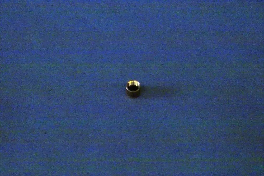 Runde, metallische Kappe auf blauer Fläche, eventuell Teil eines Heizungsventils. Sie könnte zur Brötje Produktlinie gehören.