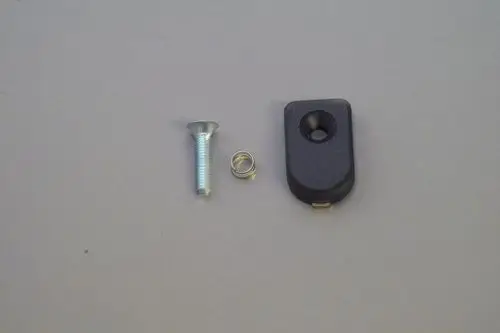 Schwarze Verkleidung mit einer Öffnung, einer Schraube und einer kleinen Feder. Teil eines Brötje Heizsystems zur Befestigung oder Abdeckung.