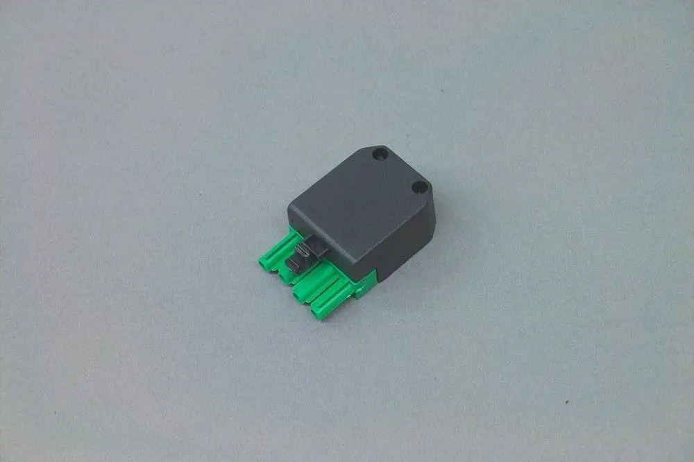 Brötje Stecker mit 4-poligem Anschluss in Schwarz und grünem Steckbereich, auf grauem Hintergrund.