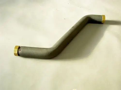 Brötje Rücklaufrohr mit gebogenem Design und zwei Anschlüssen, dargestellt vor einem neutralen, hellen Hintergrund.