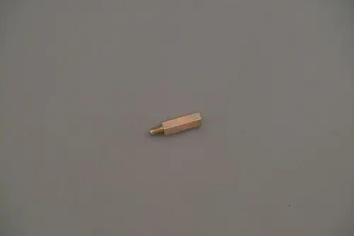 Brötje Distanzstück aus Metall, zylindrische Form mit einem Gewinde an einem Ende, auf einer grauen Unterlage abgebildet.