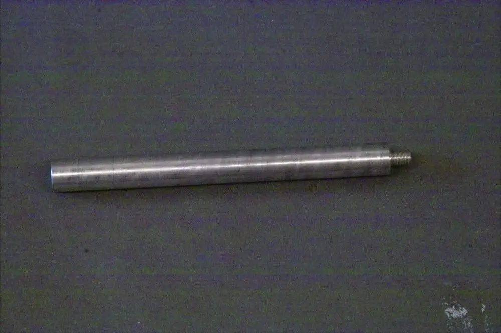 Brötje Steherblech in Metalloptik, zylindrische Form mit Gewinde am Ende, auf einem grauen Untergrund.