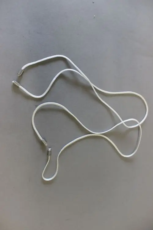 Zwei weiße, geflochtene Seile mit metallischen Enden, die für die Regelungsbox von Brötje verwendet werden. Leichte Krümmungen und Überlagerungen sind sichtbar.