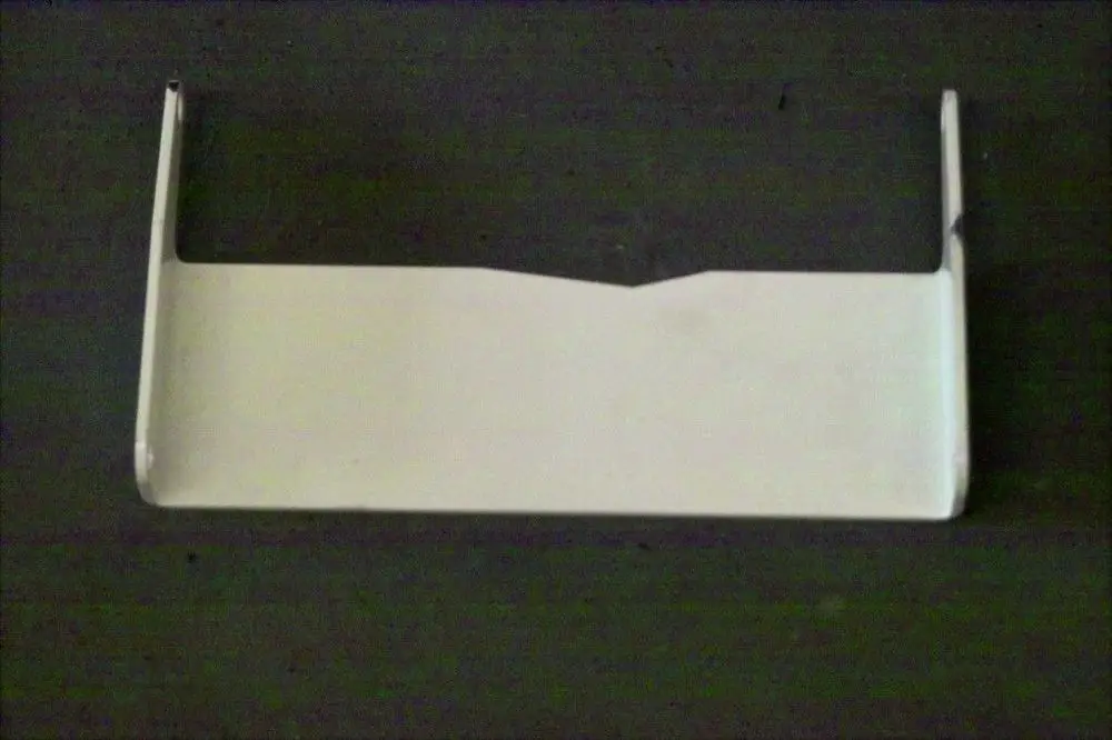 Brötje Scharnierblech in flacher, rechteckiger Form mit umgebogenen Kanten. Es ist auf einer dunklen Oberfläche platziert.