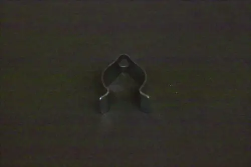 Fühlerclip von Brötje, aus Metall, mit einer offenen, geschwungenen Form und zwei seitlichen Halterungen. Auf schwarzem Untergrund präsentiert.