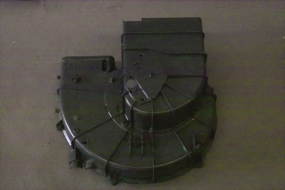 Schwarzes Ansauggehäuse von Brötje, mit mehreren Anschlussöffnungen und einer strukturierten Oberfläche. Das Gehäuse ist flach und hat eine asymmetrische Form.