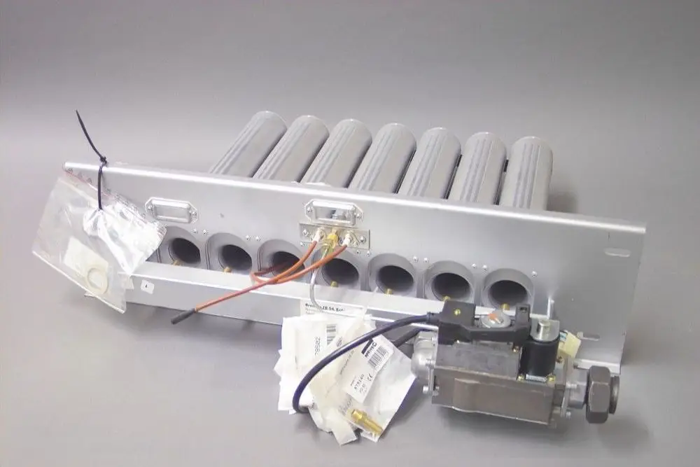 Brötje Brenner mit mehreren Rohren und einem Ventil. Zubehör wie Dichtungen und Schläuche in Tüten sichtbar. Aluminium-Gehäuse mit Anschlussmöglichkeiten.