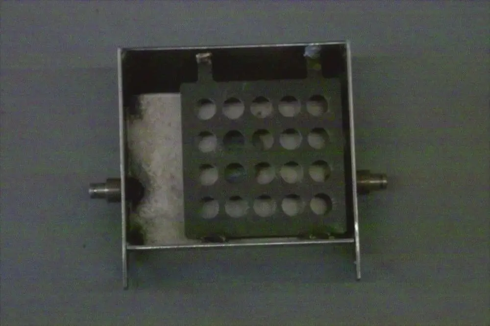 Brötje Brennerklappe aus Metall, rechteckig mit mehreren Löchern in der Mitte. Unterseite mit zwei Anschlüssen. Innenraum mit weißem Material.