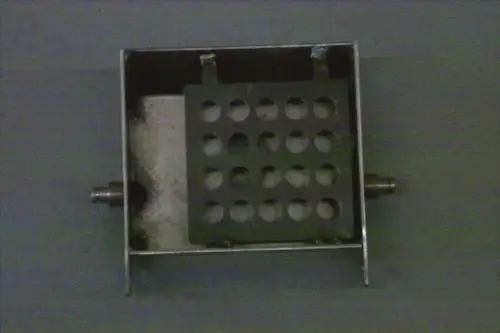 Brötje Brennerklappe aus Metall, rechteckig mit mehreren Löchern in der Mitte. Unterseite mit zwei Anschlüssen. Innenraum mit weißem Material.