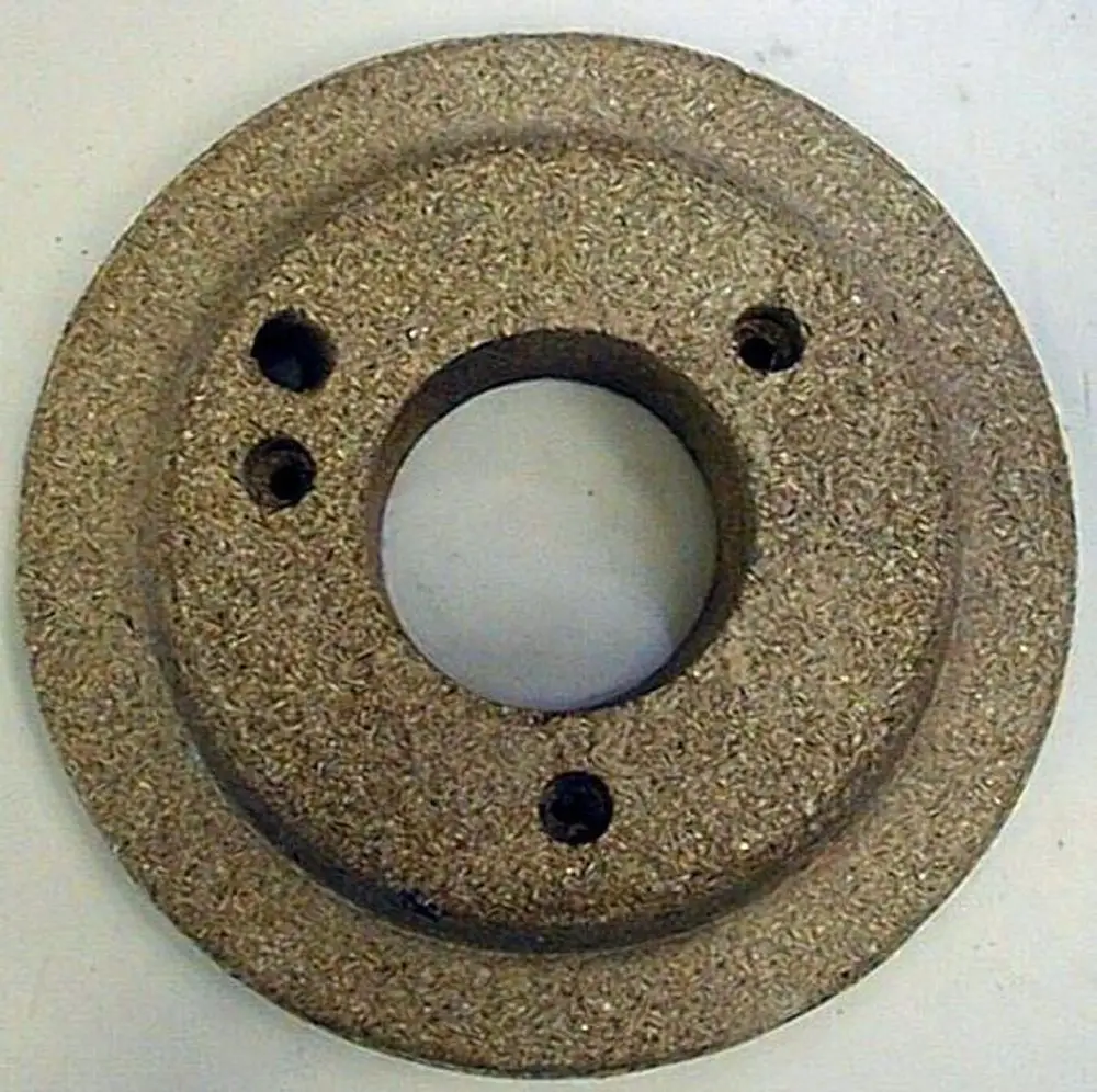 Brötje Türisolierstein in runder Form mit mittigem Loch und mehreren Befestigungsbohrungen, gefertigt aus einem grobkörnigen Material.