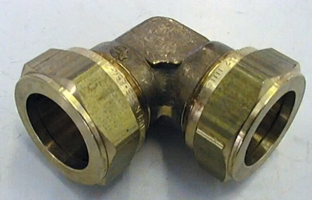 Brötje Winkelverschraubung mit zwei anschlussfertigen Öffnungen in einem 90-Grad-Winkel. Die Oberfläche ist aus Metall gefertigt.