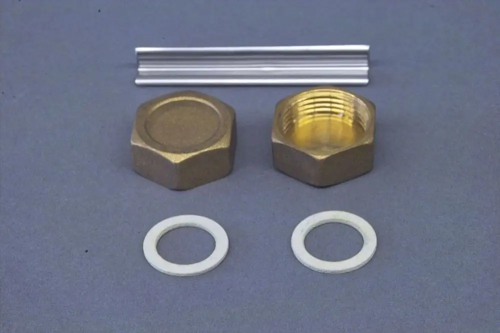 Brötje Zubehörteile bestehend aus zwei Blindkappen in Bronze, zwei Dichtungen und einem Metallprofil auf grauem Hintergrund.