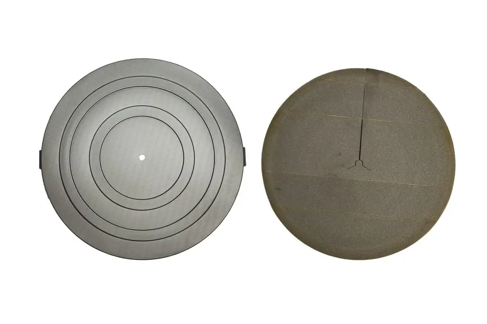 Zwei runde Isolierdeckel, einer mit konzentrischen Ringen in Grau, der andere mit einer glatten Oberfläche in Dunkelgrau, möglicherweise von der Marke Brötje.