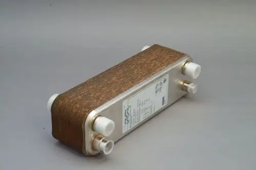 Brötje Plattenwärmetauscher mit metallischer Struktur und mehreren Anschlüssen, montiert auf grauem Untergrund.