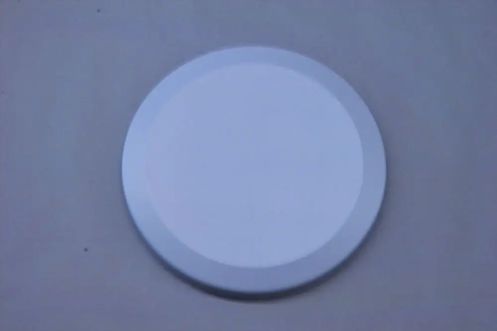 Runder, weißer Deckel von Brötje, flache Form ohne sichtbare Details oder Beschriftungen, auf einer hellen Unterlage platziert.