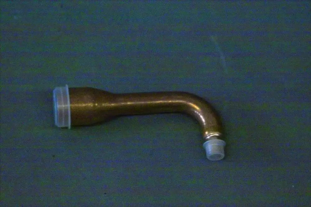 Brötje Einspritzleitung aus Kupfer mit einer abgewinkelten Form, einem breiteren Ende und zwei unterschiedlichen Steckplätzen an den Enden.